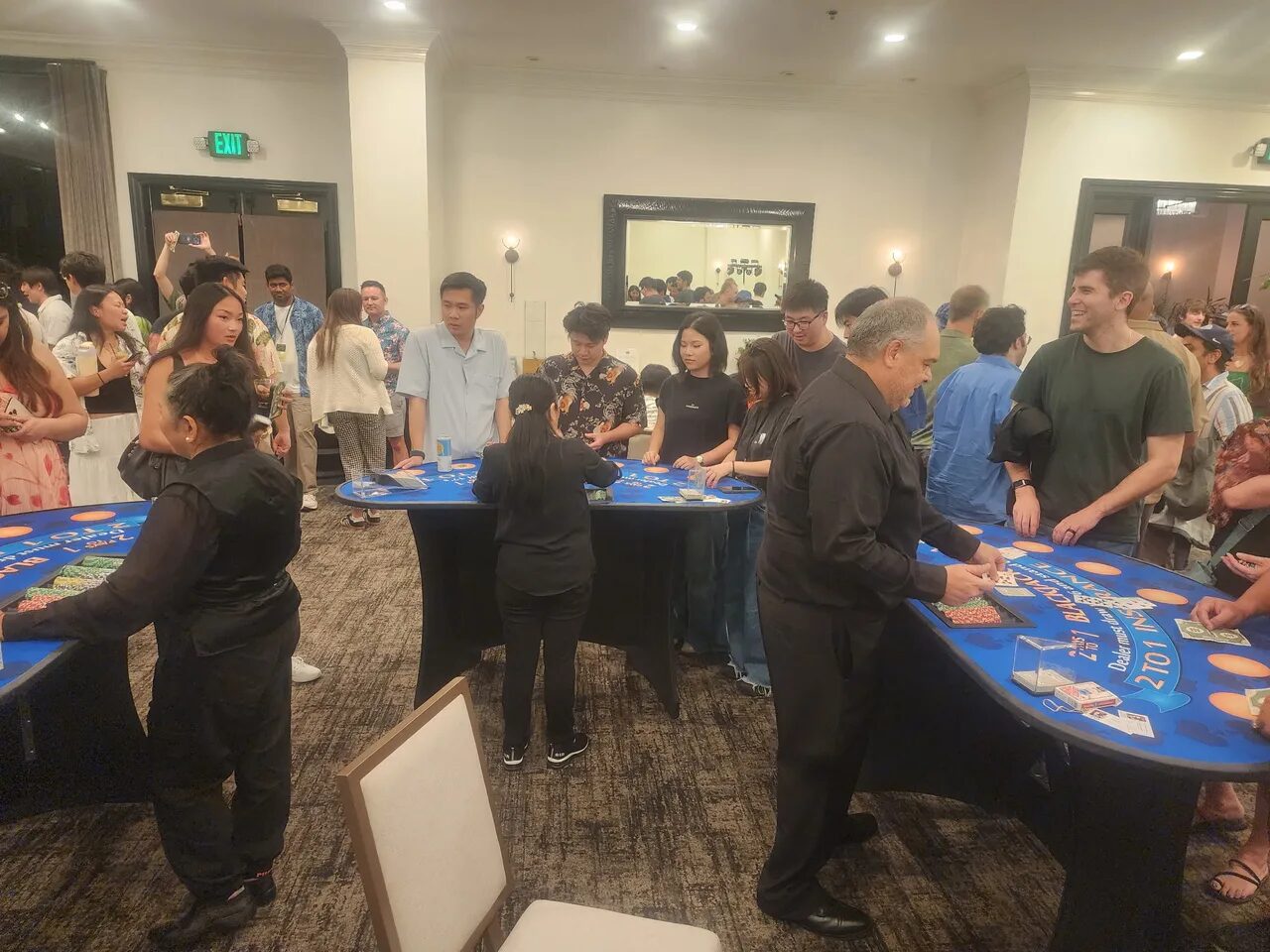 Birthday party crowd around a blackjack table at a Honolulu casino night