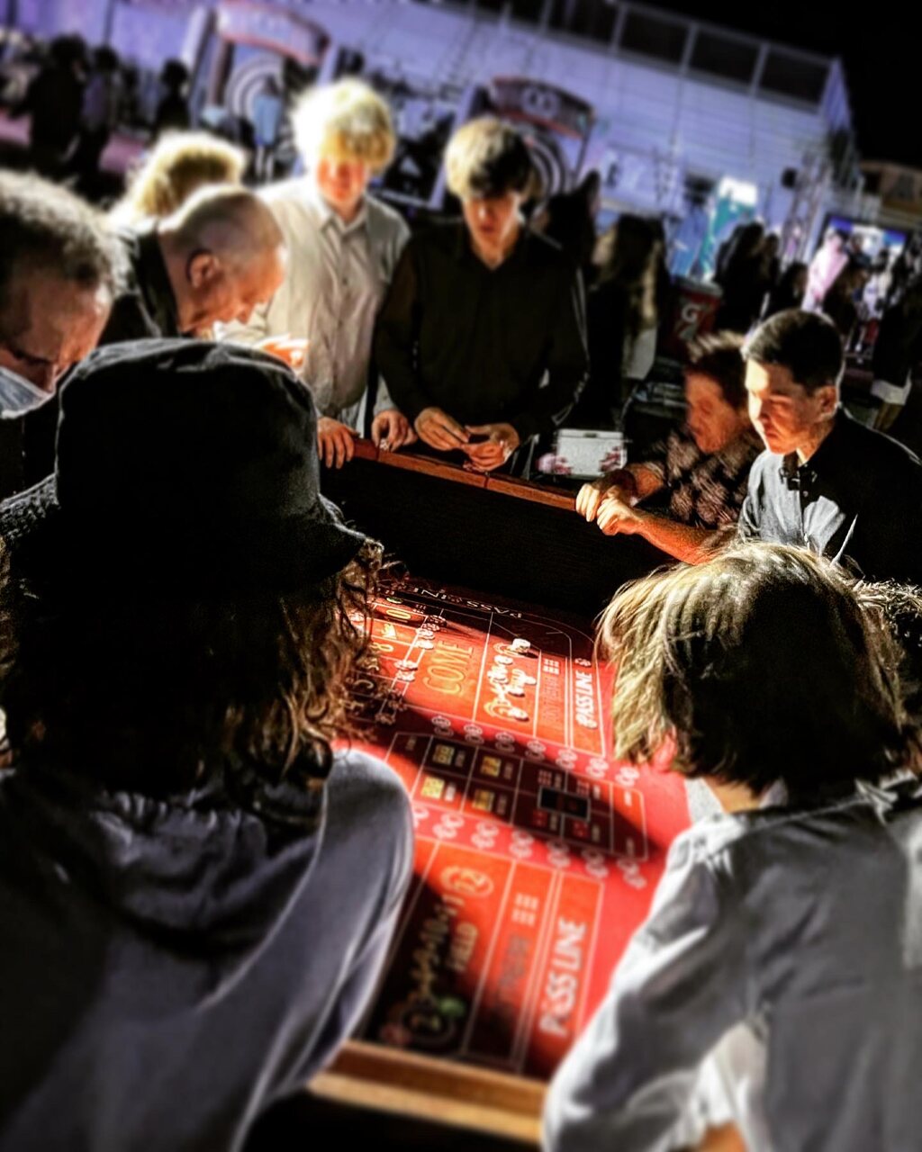 Packed casino party with guests crowding the gaming tables in Honolulu