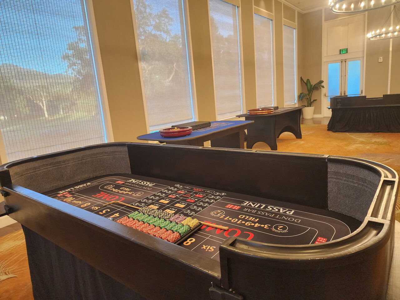 Craps table by floor-to-ceiling windows with a garden view at an Oʻahu venue